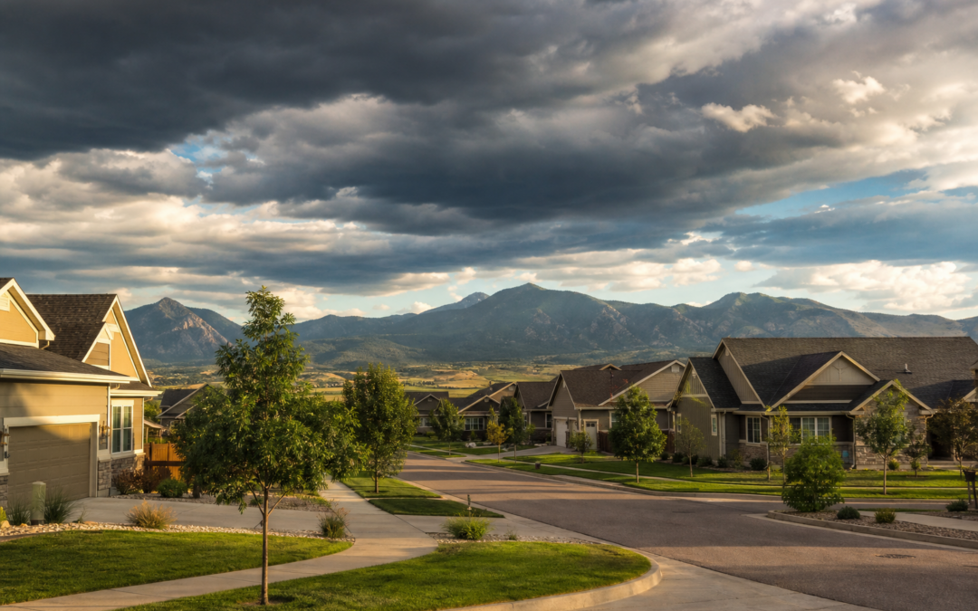 Residential neighborhood in Wellington Colorado under dramatic summer storm clouds with Front Range foothills in the background